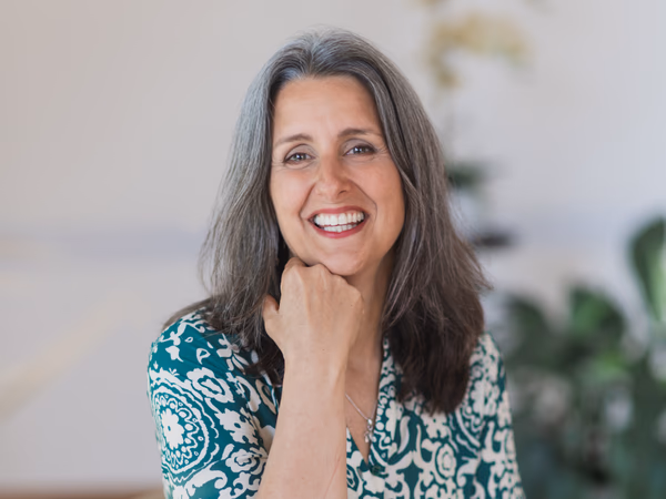 Giselle Monbiot seated and smiling in a bright, calm therapy room