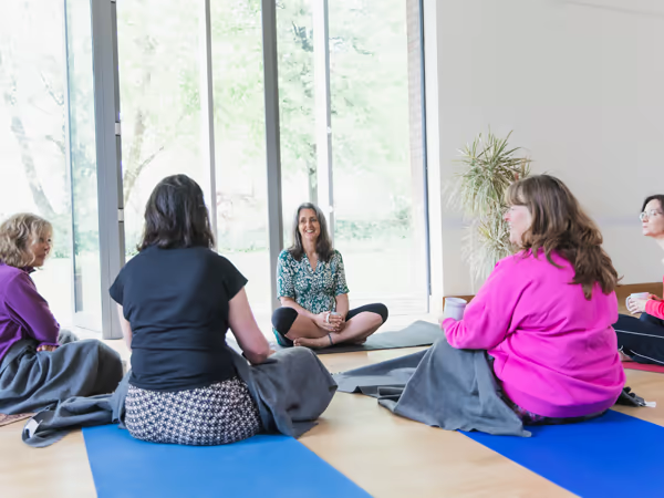 Giselle Monbiot seated in warm, gentle conversation in a calm, light-filled therapy space